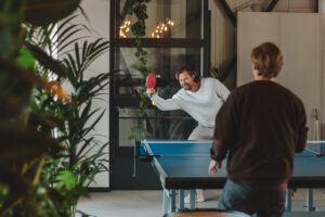 Twee mensen die tafeltennissen in Skiffa House coworking Den Haag - Scheveningen, waar werk en ontspanning hand in hand gaan.